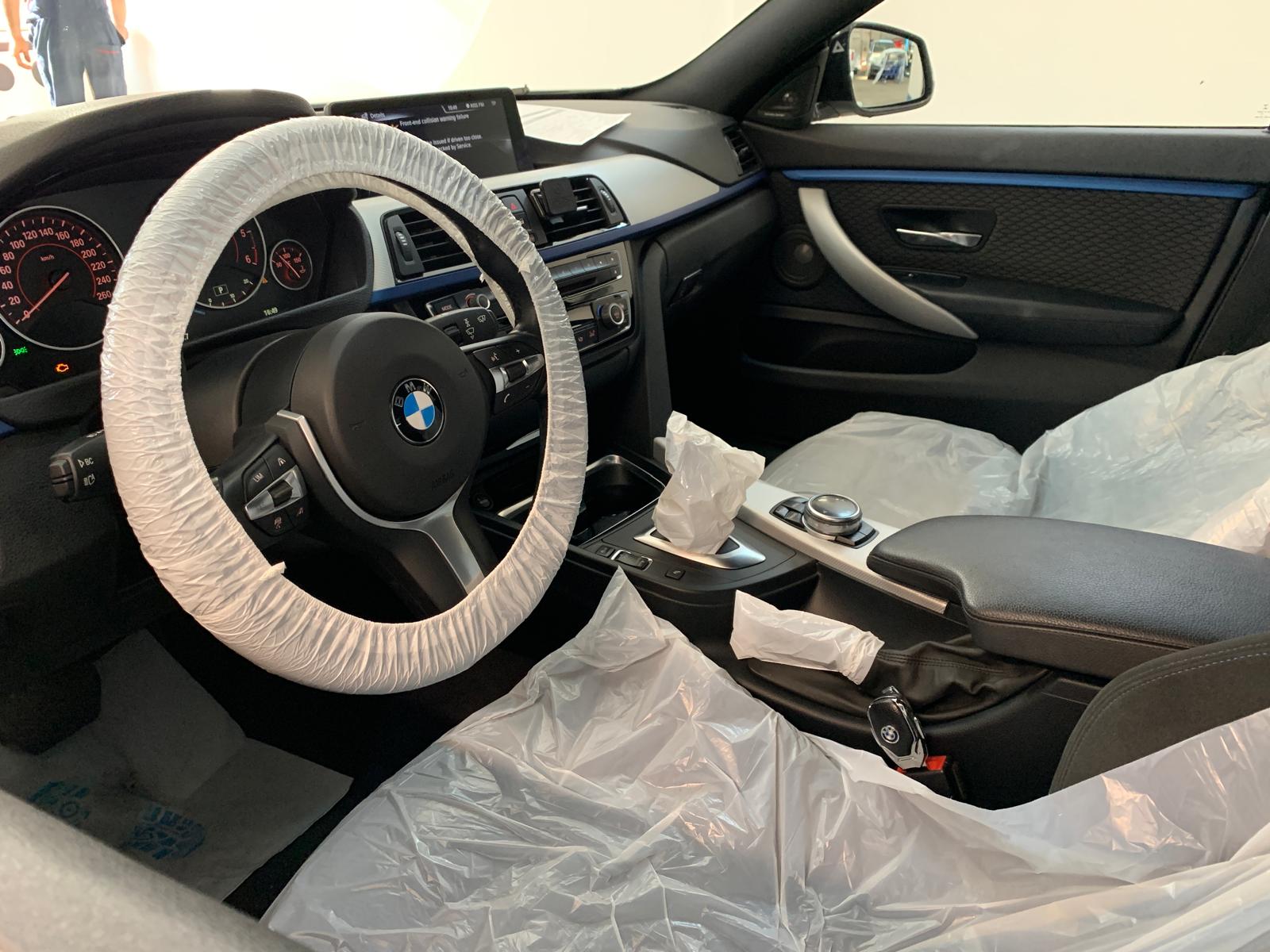 Interior BMW în timpul calibrării ADAS — ecran avertizare Front Assist activ
