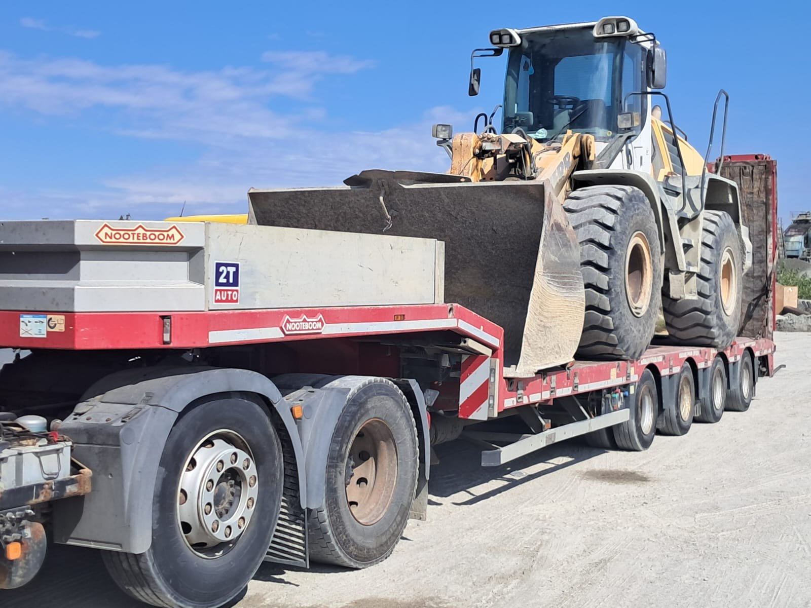 Încărcător Liebherr pe lowboy Nooteboom cu sticker 2T Auto — transport greu Caracal