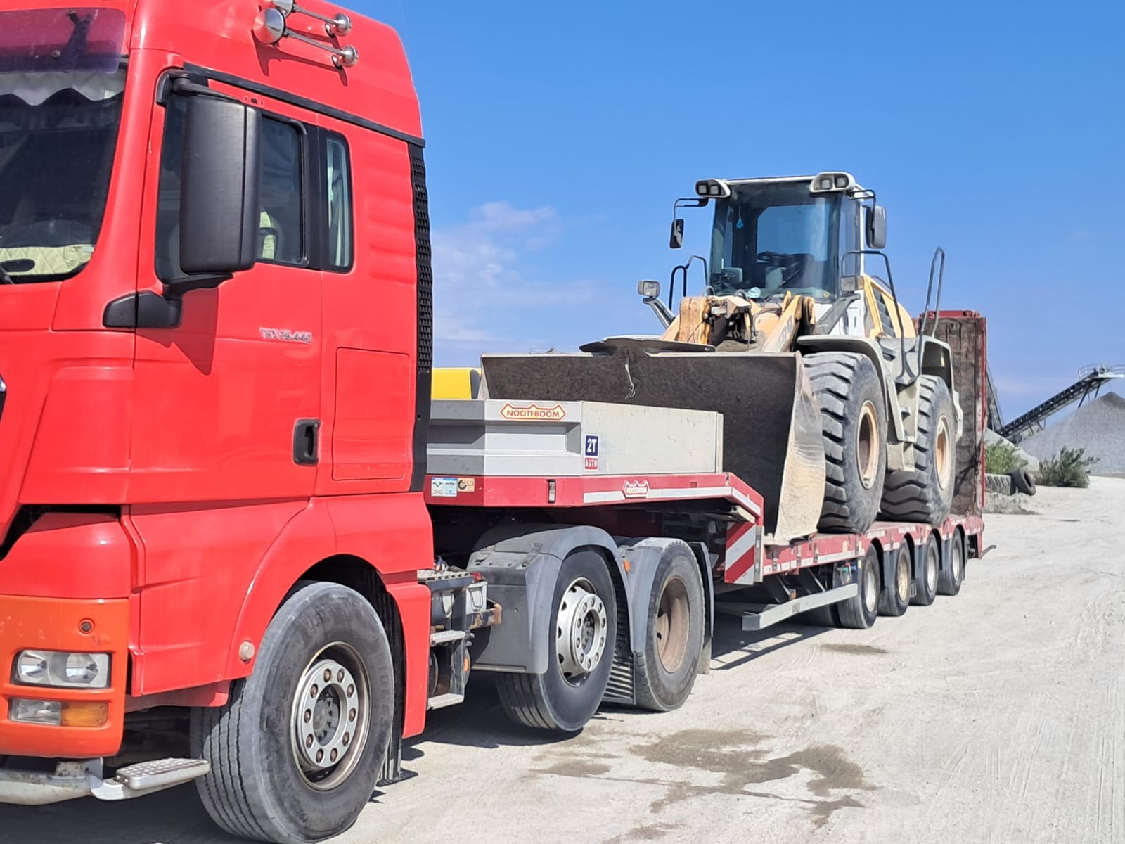 Camion roșu 2T Auto cu platformă Nooteboom și utilaj Liebherr — tractări agabaritice Caracal