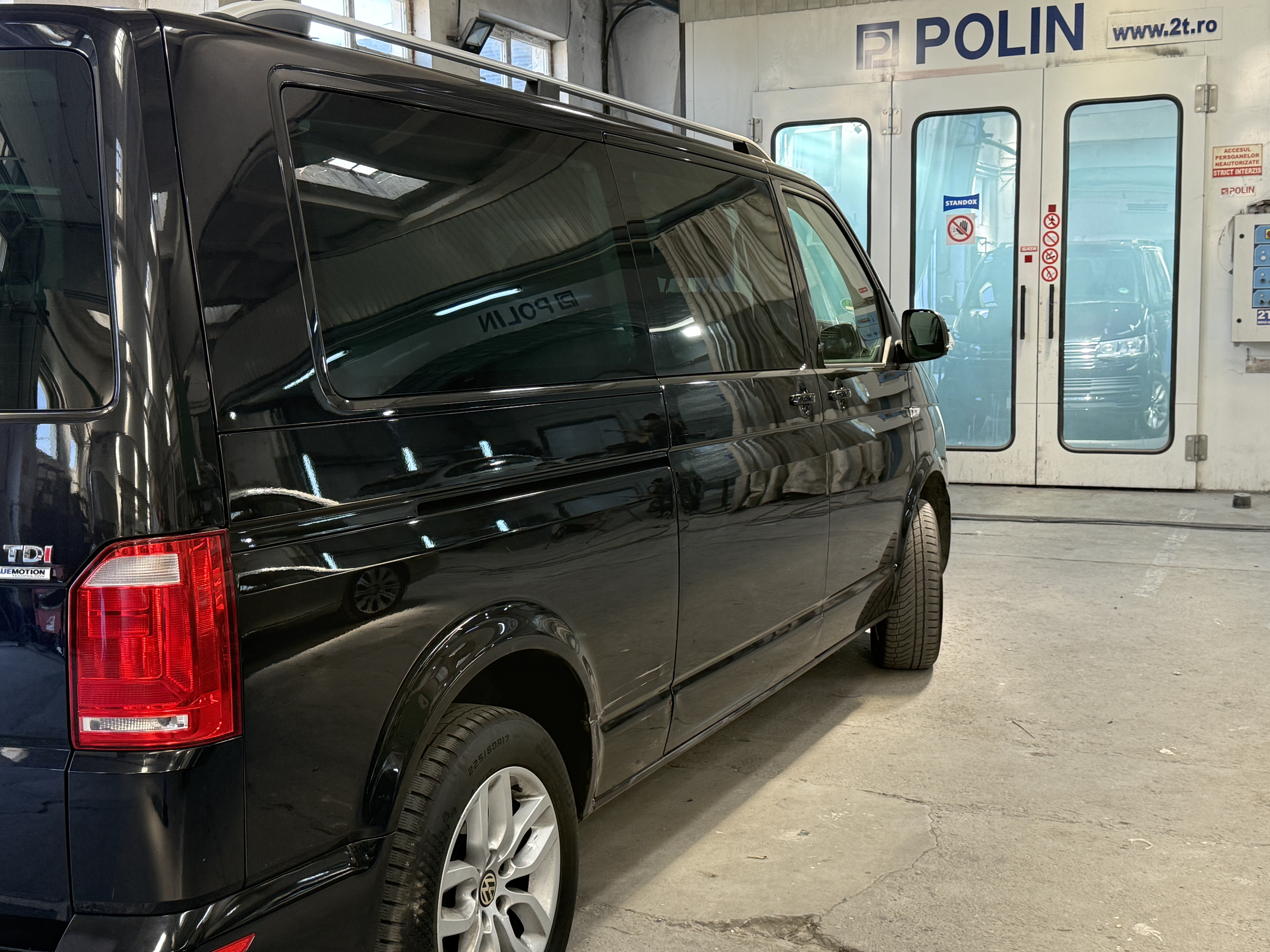 Dubă VW neagră în fața cabinei Polin www.2t.ro — vopsitorie auto Caracal